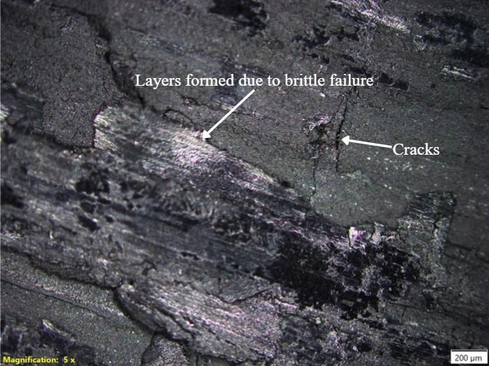 Optical micrograph of the graphene grade with peeled layers and cracks.