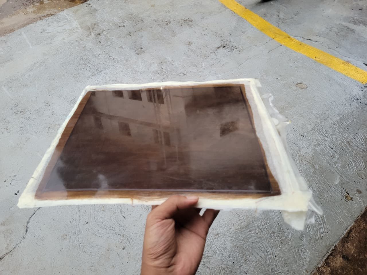 A cured natural-fibre epoxy laminate plate held in one hand